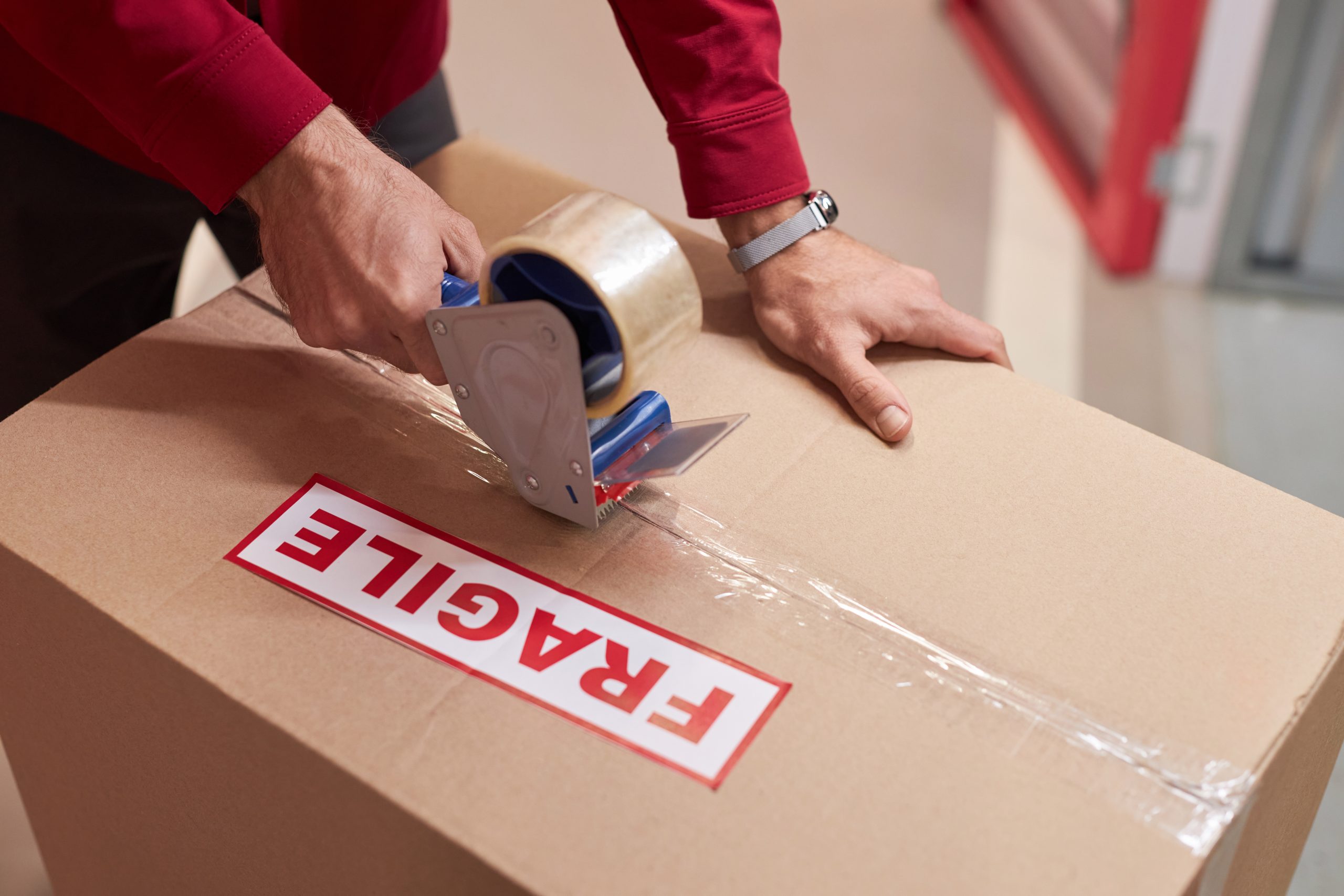 storage worker taping boxes in warehouse 2023 11 27 04 51 58 utc scaled